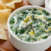 Homemade Spinach Dip · Creamy blend of spinach, topped with Parmesan cheese and served warm with crisp tortilla chi...