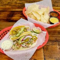 Oz Tacos · Grilled shrimp with honey lime cilantro slaw, red onion, avocado, jalapeno and jalapeno sauc...