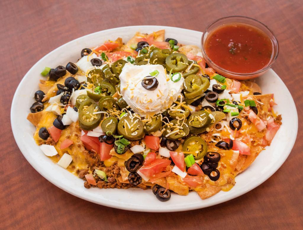 Nachos · Pile of chips topped high with taco meat, cheese, onions, tomatoes, jalapenos and olives. Served with a side of sour cream and salsa.