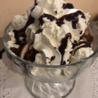 Profiterol · Ice cream with vanilla puffs, whipped cream and chocolate syrup.