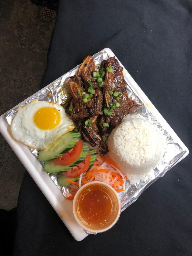 V4. Grilled Short Ribs and Rice  · Cơm sườn nướng. grilled tender beef short rib served with jasmine rice, fresh vegetables, pickled carrots & daikon slaw accompanied with a side of traditional vietnamese dipping sauce.