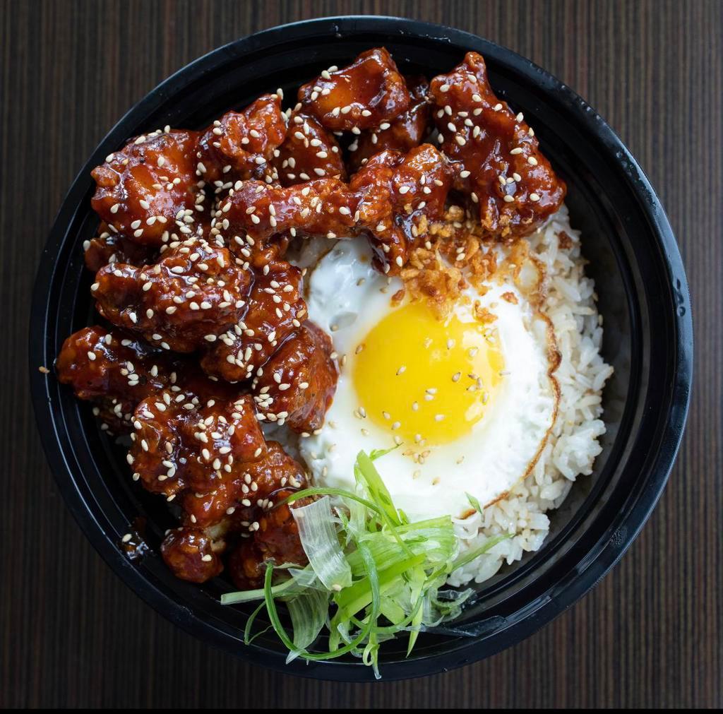 K-Chicken and Rice Bowl · Crispy Korean fried chicken (with your choice of signature sauce) over garlic fried rice topped with a fried egg, sesame seeds and scallions.