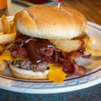 The Wrangler · A 6oz beef burger on brioche bun with cheddar cheese, bacon, onion ring, and BBQ sauce. Serv...