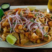 Mini Jalea · Breaded shrimp, calamari, fish and fried cassava yuca topped with marinated red onion and li...