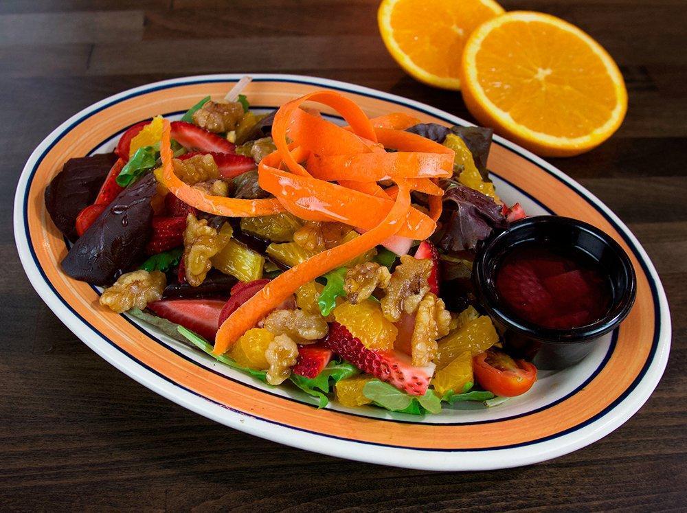 Ensalada Raices · Mesclun salad, caramel walnuts, cherry tomatoes, oranges and red onions served with a delicious homemade strawberry dressing.