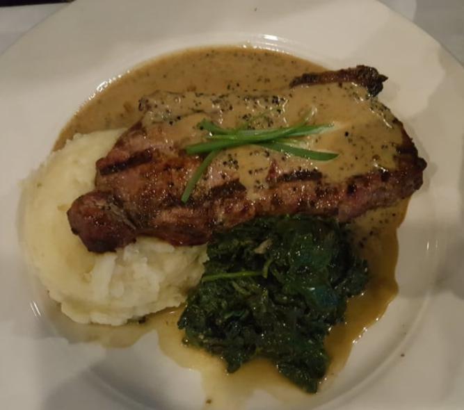 NY Sirloin · Served with roasted garlic mashed potatoes, sauteed spinach and drizzled with a 4 pepper au poivre sauce.