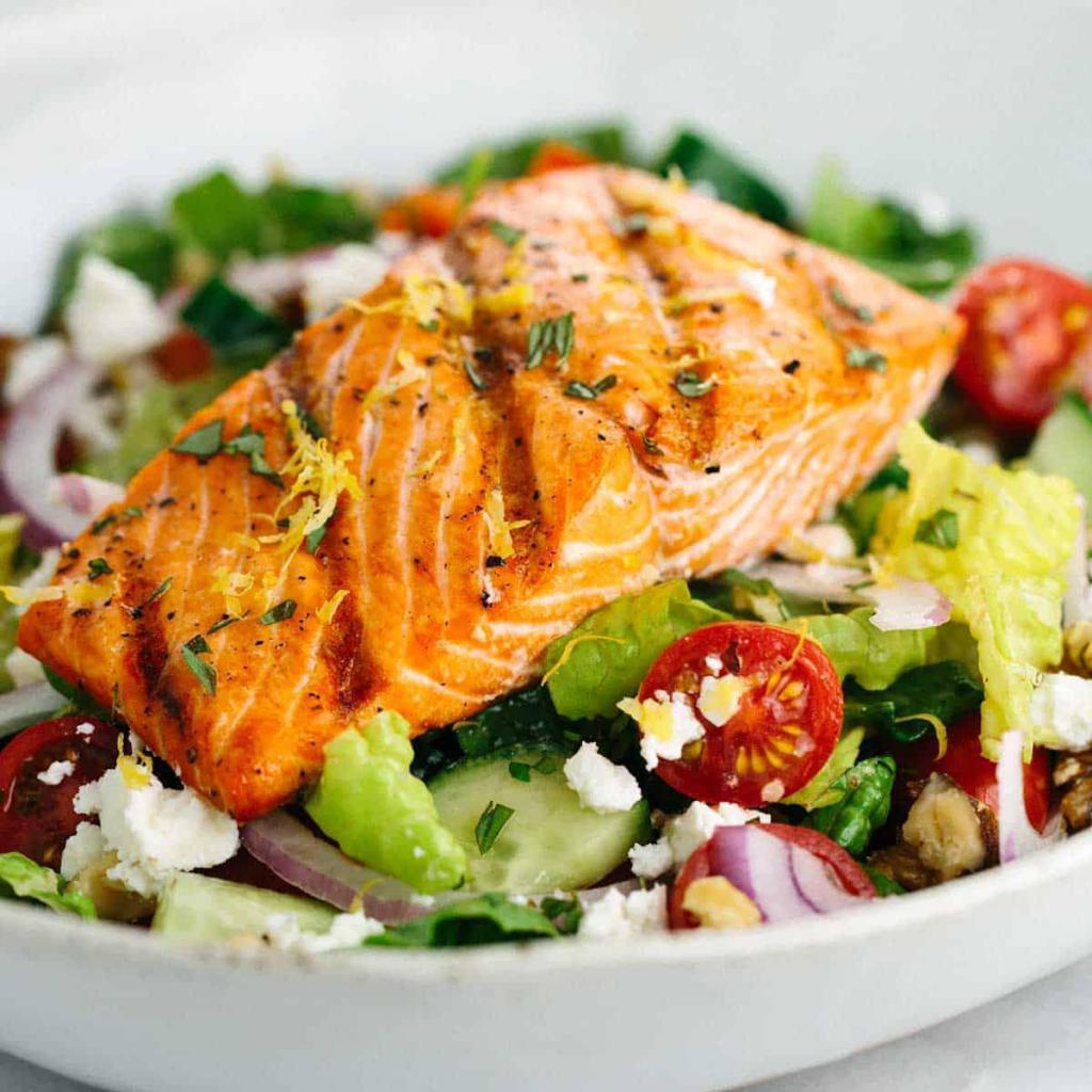 Mexican Fresh  Grilled Salmon Salad · The tender, flaky salmon counters the crunchy cucumber salad while the rich fillet balances the saltiness of feta and the tang of the salad dressingRomaine lettuce, red and yellow peppers, red onions, grape tomatoes and grilled salmon.