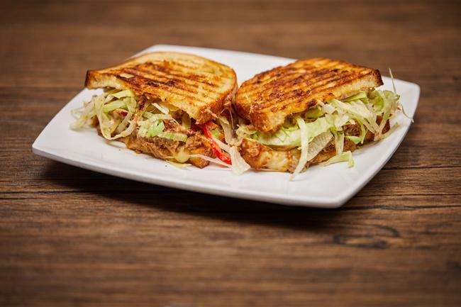 BBQ Pulled Pork Panini · Zesty BBQ dressed pulled pork, topped with melty pepper jack, tomato, and shredded lettuce.