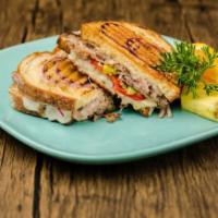 Roast Beef and Garlic Panini · Savory, tender roast beef, stacked on red bell peppers, red onion, and pepperoncini topped w...