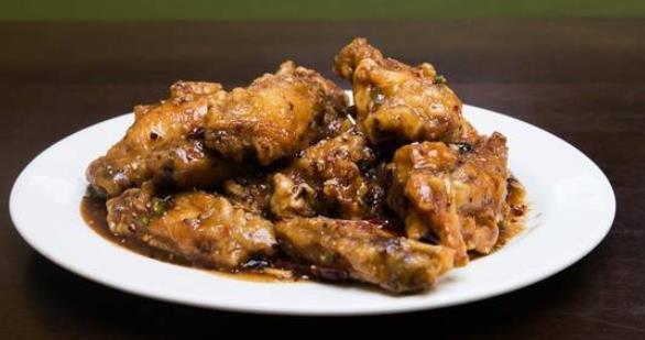 Spicy Dry Fried Chicken Wings · 10 pieces. Battered wings, minced garlic, ginger, chili pods, and dry-fry sauce.