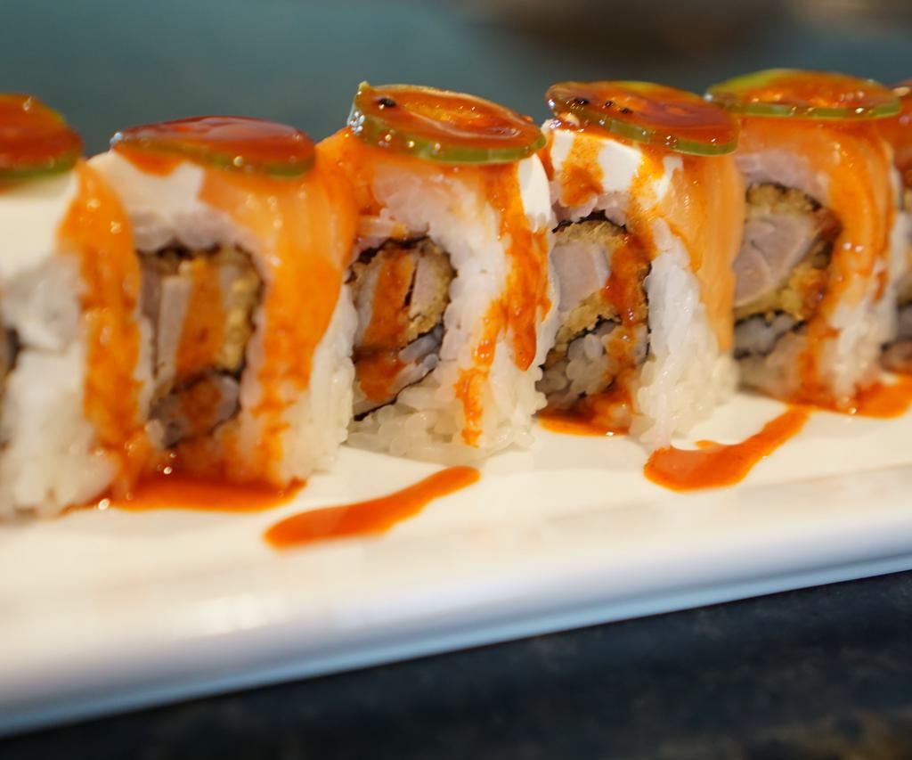 Caza Roll · Breaded tuna; topped with smoked salmon, cream cheese, jalapeño, and spicy honey sauce.