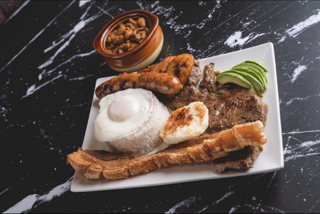 Bandeja Paisa  · Grilled steak , fried pork belly,Colombian sausage, avocado, sweet plantain,  fried egg, arepa, rice and beans 

