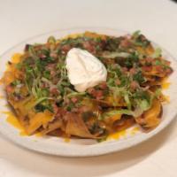 Nachos · Homemade Tortilla Chips topped with Cheddar Cheese, Beef Chili, Lettuce, Tomato Jalapeños an...