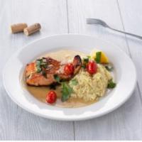 Grilled Salmon · Served with roasted garlic sauce, cherry tomatoes and saffron risotto. 