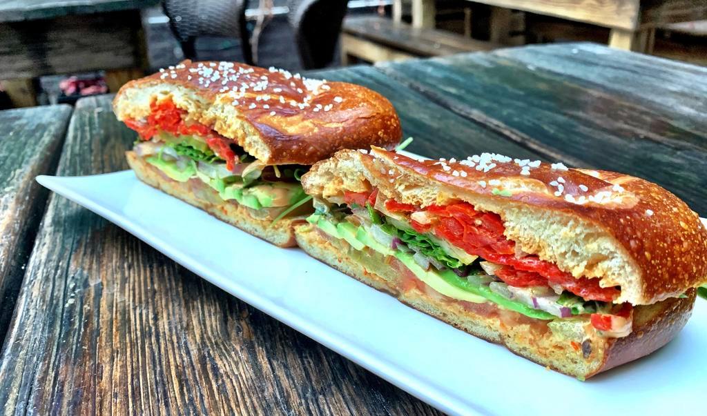 The Scoutmaster · fresh tomato, red onions, avocado, arugula, pickle chips, piquillo peppers and chipotle mayo on a soft pretzel bun (onions are mixed in with the piquillos and cannot be removed)