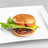 Dollies Bacon Burger · Quarter pound burger that’s pan-fried to perfection, topped with vegan bacon, crispy green l...