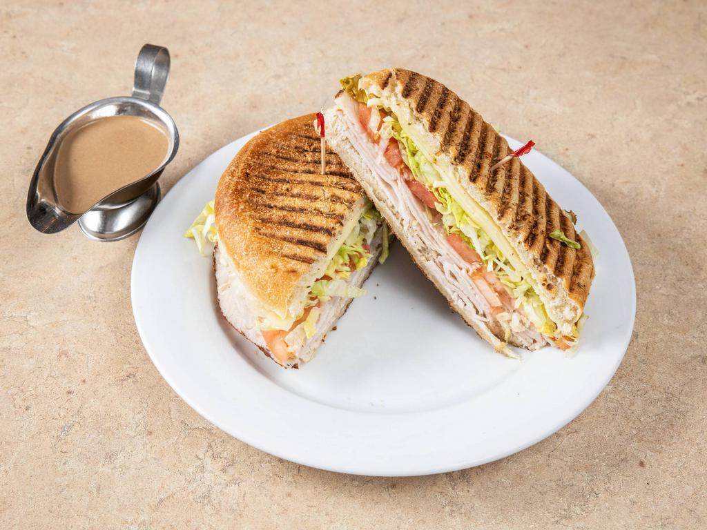 Tacchino Panini · Turkey, lettuce, tomatoes and provolone cheese. Made with homemade rosemary focaccia bread and served with a pickle spear. 