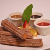 Churros · Churros - fried cinnamon pastry alongside chocolate & strawberry sauces for dipping.