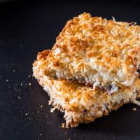 Magic Coconut Bar · Shredded coconut, walnuts and chocolate chips caramelized in layers in a graham cracker crust.