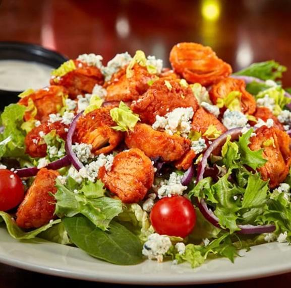 Kick-In Buffalo Chicken Salad · Fried Chicken Strips cut & tossed in Famous Hot Sauce, on bed of greens, cheese, tomato, bacon, your 
choice of dressing