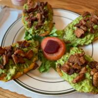 Tostones with Homemade Guacamole and Chicharron · Green plantains topped with homemade guacamole and pork crackling. 