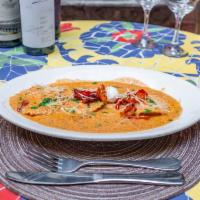 Lobster ravioles · Cooked in a creamy rocoto sauce, red bell peppers, parmesan cheese, cilantro