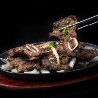Korean Kalbi Plate · Marinated beef short ribs grilled with onion and scallions topped with Korean red chili sauce.