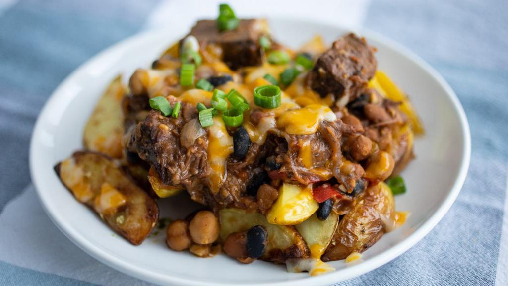 Chili Cheese Roastie · Roasted potato spears slathered in colby jack cheese and our hearty beef and three bean chili. Gluten-free.