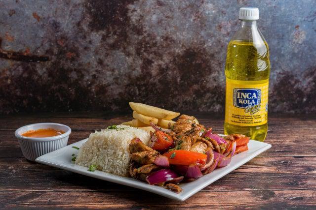 Pollo Saltado · Chicken, tomato, onion sautéed in a fiery wok with french fries and white rice.