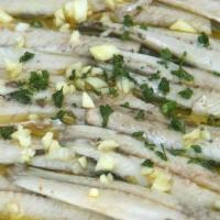 Boquerones en Vinagre · Marinated white anchovies, tomato, garlic and parsley.