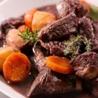 Boeuf Bourguignon · Beef stew marinated with herbs, cooked with bacon, vegetables and red wine served with boile...
