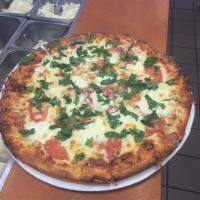 Margarita Pizza · White pizza with fresh mozzarella, fresh basil, tomatoes and Romano cheese.
