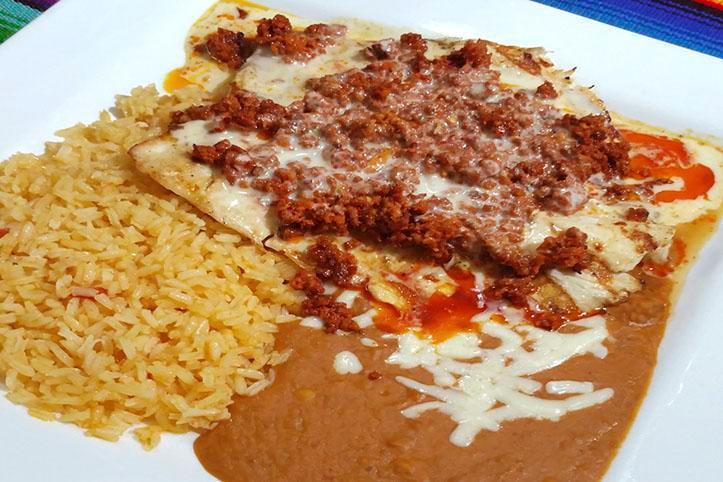 Chori Pollo · Grilled chicken breast topped with chorizo Mexican sausage and our famous cheese sauce. Served with rice, beans refried or black and tortillas flour or corn.