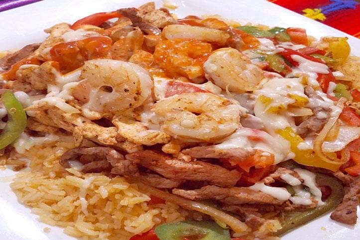 El Loro Lindo · Grilled steak, chicken, and shrimp, mixed bell peppers, tomatoes, and onions. Served with rice and topped with our famous cheese dip and enchilada sauce.