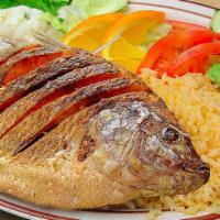 Mojarra Frita · A whole fried tilapia served with rice, lettuce, guacamole, fresh tomatoes, and tortillas,