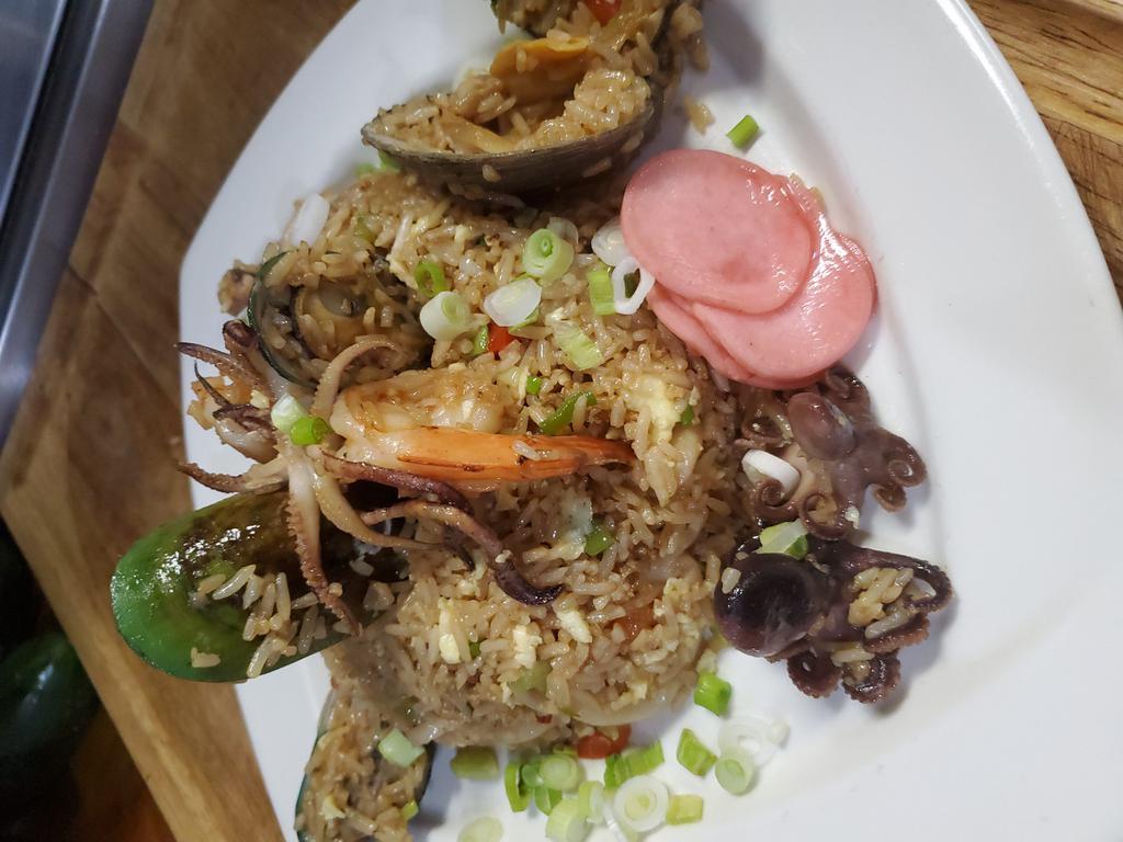 Chaufa de Mariscos (Seafood Fried Rice) · Mussels, calamari, clams, shrimps mixed with Jasmine rice, eggs, scallions, peppers, soy sauce & sesame seeds.