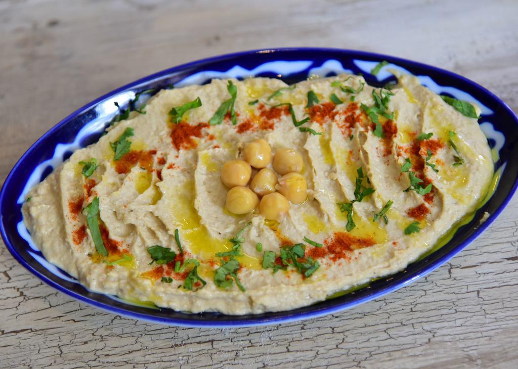 Hummus · Mashed chickpeas blended with tahini, olive oil, lemon juice, salt, and garlic.