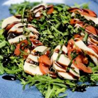 Caprese Salad · A salad with fresh Mozzarella, tomatoes, arugula, and a balsamic glaze.