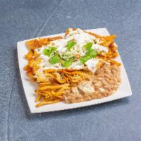 Chilaquiles · Strips of fried corn tortillas simmered in salsa, topped with eggs, cheese, onions and cilan...