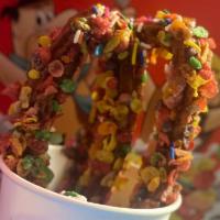 Rainbow churros · Delicious homemade churros topped with glazed caramel and fruity pebbles accompanied by stra...