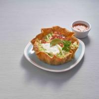 Taco Salad · Traditional crispy tortilla bowl filled with pulled chicken or ground beef and refried or bl...