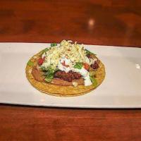 Tostada · An open faced hard shell corn tortilla with beans, lettuce, tomato, sour cream, cheese and y...