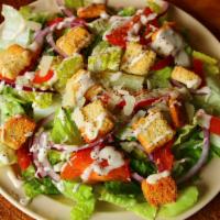 Caesar salad · Lettuce, onions, tomatoes, croutons, garneshed with black pepper and shaved parmesan and Cae...