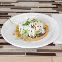 Tostada Regular (with vegetarian options) · Crispy flat tortilla topped with: refried beans, lettuce, tomato, sour cream, cotija cheese ...