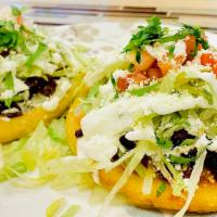 Sope with meat  · Homemade flat corn dough topped with: refried beans, lettuce, tomatoes, sour cream, cotija c...