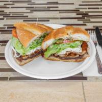Torta · Toasted torta bread, mayonnaise, lettuce, tomato, Oaxacan cheese, avocado, refried beans and...