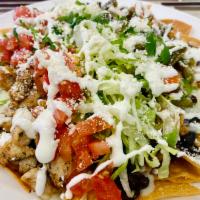 Nachos con carne  · Tortilla chips topped with black beans, mozzarella cheese, tomatoes, lettuce, cotija cheese,...