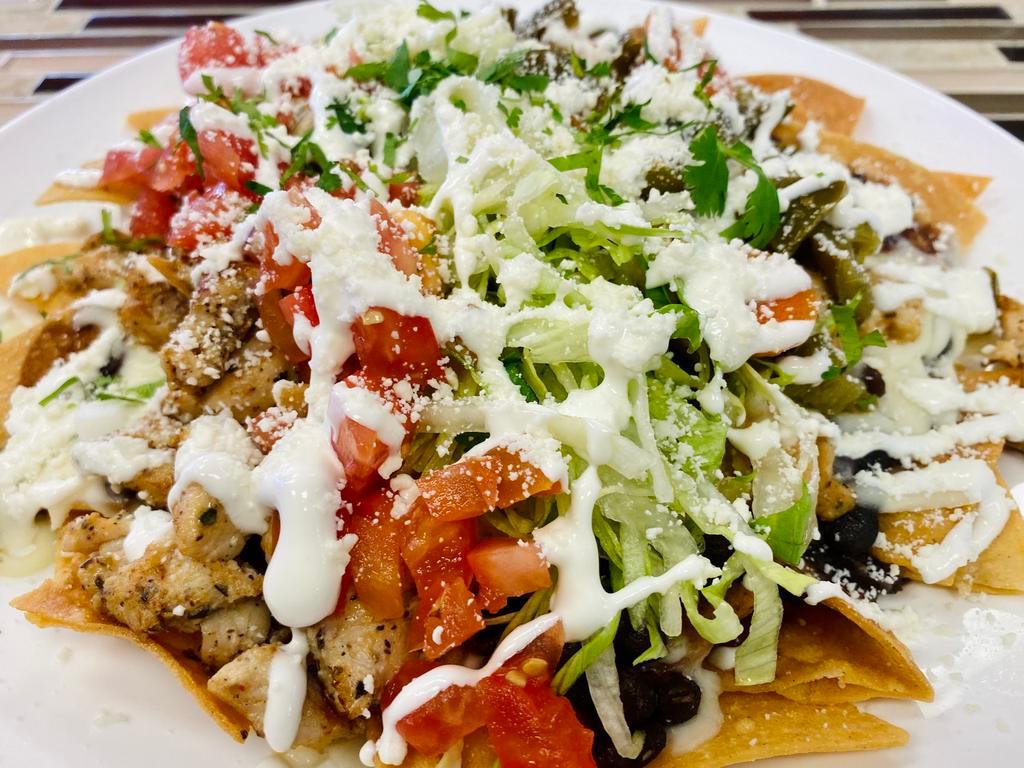 Nachos con carne  · Tortilla chips topped with black beans, mozzarella cheese, tomatoes, lettuce, cotija cheese, sour cream and jalapenos. (choice of meat)