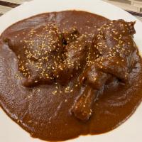 Mole Poblano · Traditional Mexican sauce of dried chiles, peanuts, almonds, and chocolate over chicken. Ser...