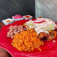 Enchilada Plate · 3 corn tortillas in deep homemade sauce with shredded chicken, rice, beans, lettuce, fresh c...